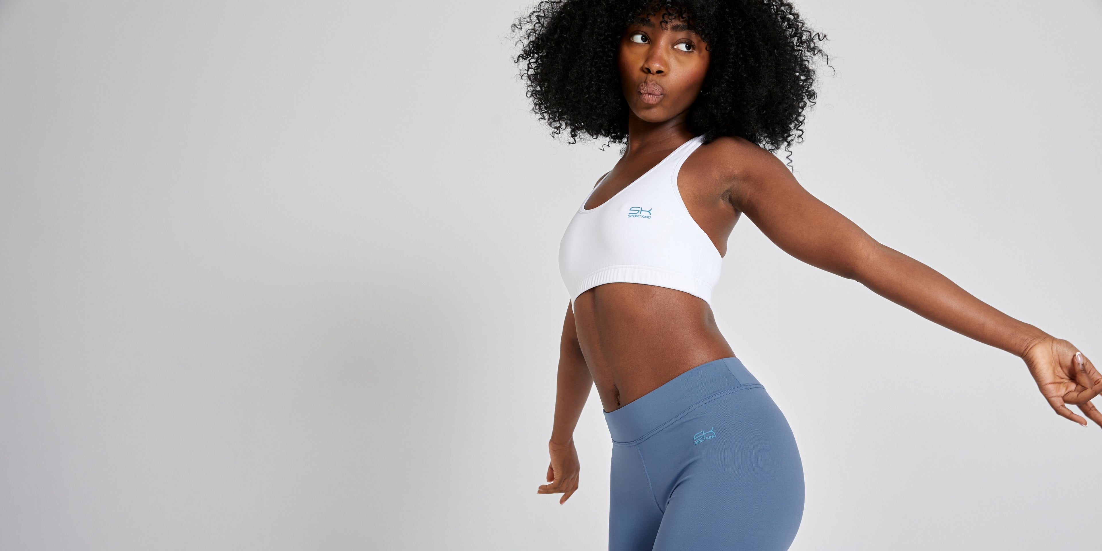 Dame mit weißem Sport BH und grauer Leggings von SPORTKIND